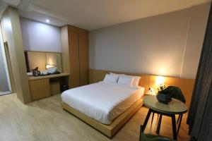 a bedroom with a white bed and a table at Daedunsan Hotel in Wanju +17 photos