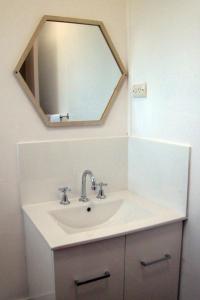 a white sink sitting under a mirror in a bathroom at Childers Budget Accommodation in Childers
