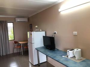 una cucina con frigorifero e tavolo con TV di Childers Budget Accommodation a Childers