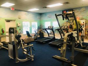 einen Fitnessraum mit mehreren Laufbändern in einem Zimmer in der Unterkunft Beautiful 3 Bedroom Apartment minutes from Disney! in Kissimmee
