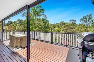 una terraza con una mesa y una parrilla. en Red Gum Cottage, en Eagle Heights