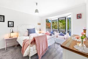 1 dormitorio con 1 cama con almohadas rosas y azules en Red Gum Cottage, en Eagle Heights