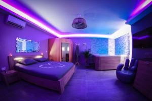 um quarto roxo com uma cama e uma banheira em Nuit vip spa sauna privatif em Le Rove