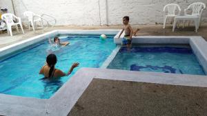 two children playing with a ball in a swimming pool at Hotel Neiva Providencia in Neiva