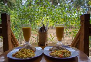 two plates of food and two glasses of orange juice at Nusa Penida Pudak Nature Bungalow in Nusa Penida +16 photos