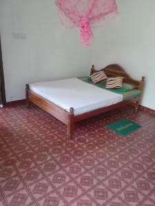 a bed in a room with a red carpet at Jungle House Tourist Inn in Dambulla