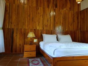 a bedroom with a bed with a wooden wall at Free Beach Resort in Phú Quốc