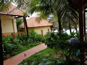 a house with a palm tree and a walkway at Free Beach Resort in Phú Quốc