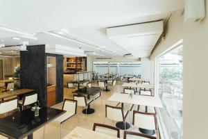 a restaurant with tables and chairs and a large window at Seasons Siam Hotel in Bangkok