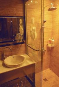 a bathroom with a sink and a glass shower at Xitang River Time Inn in Jiashan