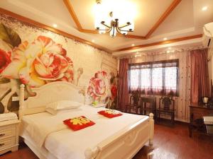 a bedroom with a white bed with flowers on the wall at Xitang River Time Inn in Jiashan