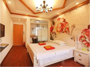a bedroom with a white bed and a painting on the wall at Xitang River Time Inn in Jiashan
