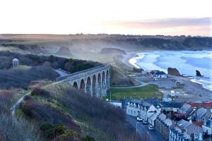 a view of a town with a bridge and the ocean at Portknockie 17 Harbour Place Overlooking Harbour in Portknockie