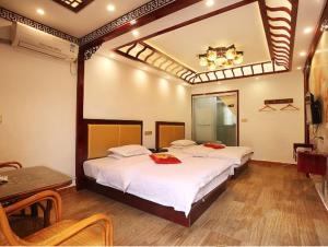 a bedroom with two beds and a table and a mirror at Xitang River Time Inn in Jiashan