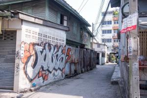 un callejón con graffiti al lado de un edificio en ninaguesthouse, en Bangkok