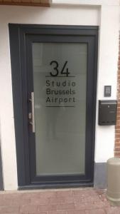 eine Tür zu einem Gebäude mit einem Schild darauf in der Unterkunft Studio Brussels - EU-District in Zaventem