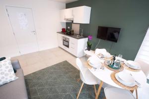 a kitchen with a table and white chairs in a room at Studio Brussels - EU-District in Zaventem