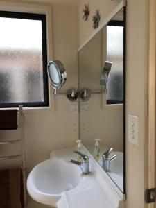 a bathroom with a sink and a mirror at Hahei Retreat in Hahei
