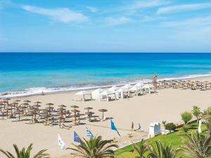 une plage avec des chaises et des parasols et l'océan dans l'établissement Sea view cozy studio near center of Rethymno town&free parking, à Réthymnon