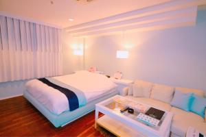 a bedroom with a bed and a couch at Hotel Aqua Vitae (Adult Only) in Nasu