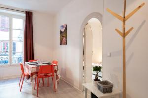 une salle à manger avec une table et des chaises rouges dans l'établissement Appartement cœur de ville - Wifi - Lave-sèche linge, à Pau