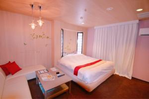 a small bedroom with a bed and a couch at Hotel Aqua Vitae (Adult Only) in Nasu