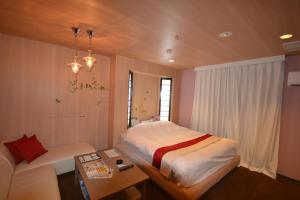 a bedroom with a large bed and a couch at Hotel Aqua Vitae (Adult Only) in Nasu