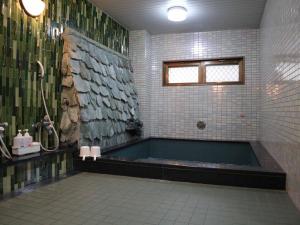 Kimatsu Ryokan في هيروشيما: حمام مع حوض استحمام ودش