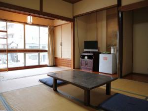 廣島的住宿－Kimatsu Ryokan，客厅配有桌子和冰箱