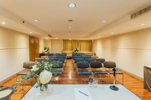 a conference room with a row of chairs and flowers at Seasons Siam Hotel in Bangkok