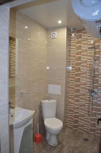 y baño con aseo, lavabo y ducha. en Central Apartment 4, en Stara Zagora