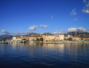 a marina with boats in the water and buildings at Résidence Suarella in Saint-Florent