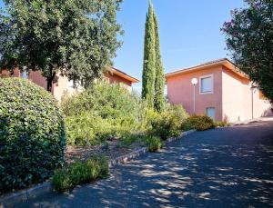 a street in front of a building with a tree at Résidence Suarella in Saint-Florent