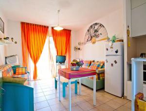a kitchen with a table and a refrigerator at Résidence Suarella in Saint-Florent