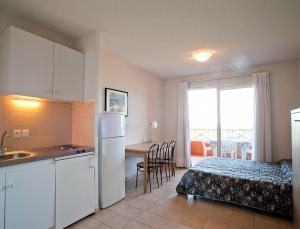 a kitchen and a bedroom with a bed and a table at Résidence Suarella in Saint-Florent