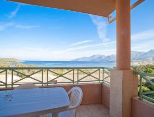 a table and chairs on a balcony with a view of the ocean at Résidence Suarella in Saint-Florent
