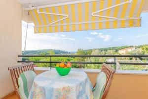 a table with a bowl of fruit on a balcony at Apartment IRENA with Bikes included in Pula