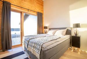 a bedroom with a bed and a large window at Riverside luxury suites in Rovaniemi