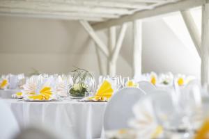 a white table with white chairs and glasses on it at Van der Valk Golfhotel Serrahn - Adult Only in Serrahn