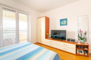 a bedroom with a bed and a flat screen tv at Apartment IRENA with Bikes included in Pula