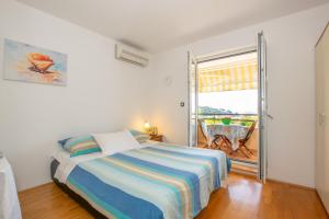 a bedroom with a bed and a large window at Apartment IRENA with Bikes included in Pula