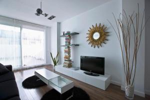 a living room with a tv and a table at Cool Loft Malvarrosa Beach in Valencia