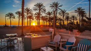 - une vue sur une plage bordée de palmiers et le coucher du soleil dans l'établissement Cool Loft Malvarrosa Beach, à Valence
