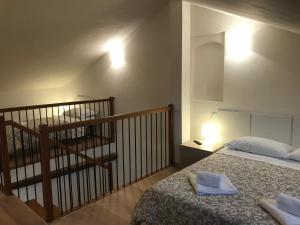 a bedroom with a bed and a staircase with a stair case at APPARTAMENTI del DUCA in Ferrara