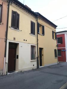 a white building with a door and a street at APPARTAMENTI del DUCA in Ferrara