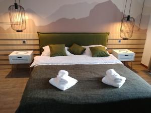 a bedroom with a large bed with towels on it at DOR Apartment in Poiana Brasov