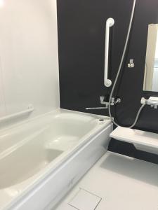 a white bath tub in a bathroom with a sink at Villa Paolo in Furano
