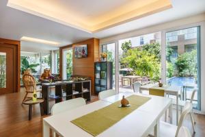 a living room with white tables and chairs and windows at U Tiny Boutique Hotel Suvarnabhumi Bangkok - SHA Plus in Lat Krabang