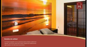 a bedroom with a poster of a beach at Hostal Boutique El Patio Lepe in Lepe