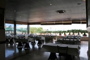 a restaurant with tables and chairs and a large window at Holiday Suites Hotel & Beach Resort in Jounieh